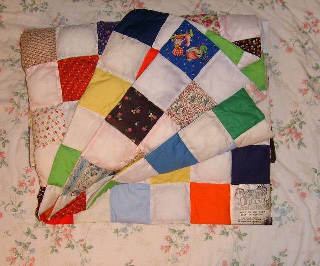 Mom designed this simple quilt. She made each square individually, then stitched them together. When the quilt is completely laid out,  on one side every other square is a prety pattern (the in-between squares are plain white or pink), and when you flip it over, the colored squares are solids. This quilt is washable. And in the lower right corner, she printed the Down on the Farm logo from the annual 4th of July Crafts Festivals she hosted at our farm in Blue Ball in the 1970s-'80s.